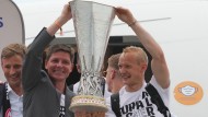Hand an Hand: Eintracht-Trainer Oliver Glasner (links) und Kapitän Sebastian Rode präsentieren den Pokal am Frankfurter Flughafen.